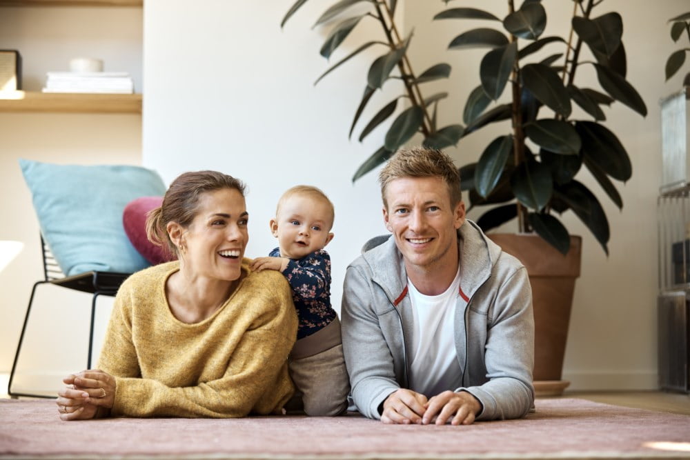 Familie på tre ligger på gulvet